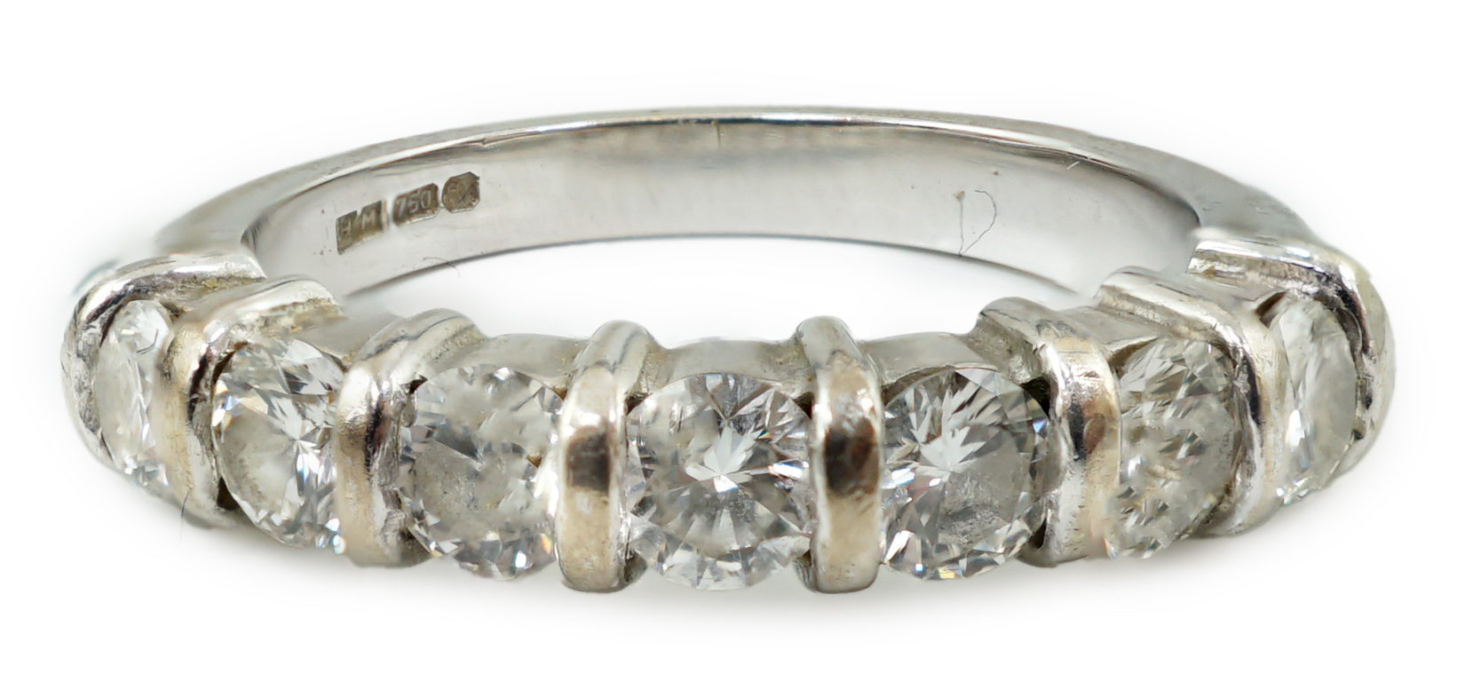 A modern 18ct white gold and seven stone round brilliant cut diamond set half hoop ring